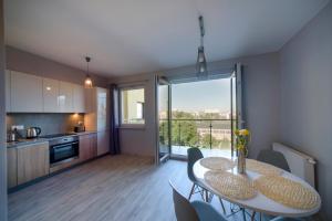 a kitchen and dining room with a table and chairs at Apartamenty City View od WroclawApartament-pl in Wrocław