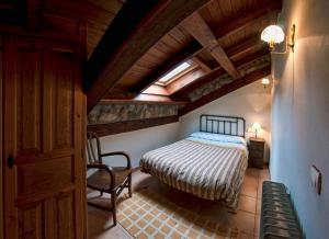 a bedroom with a bed and a chair in a room at El Invernal de Picos in Portilla de la Reina