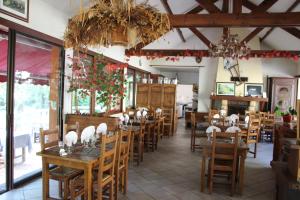 a restaurant with wooden tables and chairs in a room at Hotel Restaurant Les Gorges de Chouvigny in Chouvigny