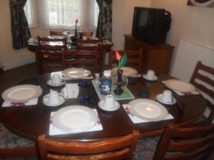 a dining room table with white plates on it at Braemer Guest House in Derby