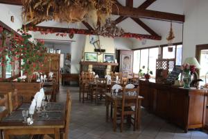 a restaurant with tables and chairs in a room at Hotel Restaurant Les Gorges de Chouvigny in Chouvigny