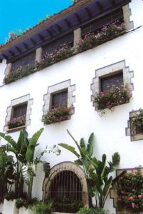 
a building with a bunch of plants in front of it at Boutique Hotel Davallada- Adults Only in Sitges
