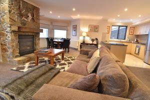 a living room with a couch and a fireplace at Hotel Pension Grimus in Mount Buller