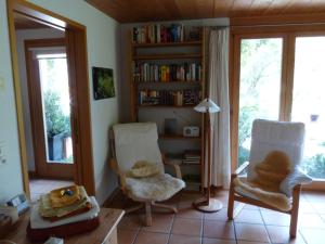 a living room with two chairs and a book shelf at Dunkel Blaue Maus in Meiringen