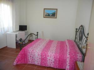 a bedroom with a pink bed and a desk at B&B Stella Marina in Soverato Marina