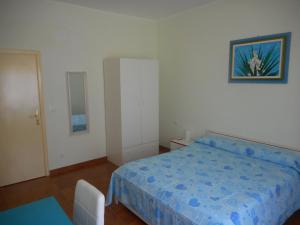 a bedroom with a bed with a blue comforter at B&B Stella Marina in Soverato Marina
