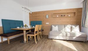 a living room with a table and a couch at Ferienwohnungen Rahm in Mayrhofen