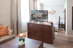 a living room with a flat screen tv on a stand at Boutique Hotel Adria in Wels
