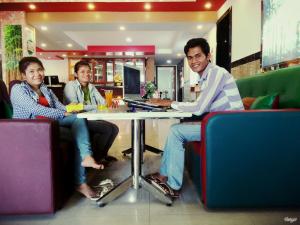 three people sitting at a table in a restaurant at Soben Sensok Guesthouse in Phnom Penh