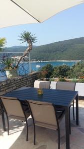 a blue table and chairs with a view of the water at Rabac 1 in Rabac