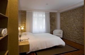sypialnia z białym łóżkiem i oknem w obiekcie Hotel de Naturaleza AV w mieście Ameixenda