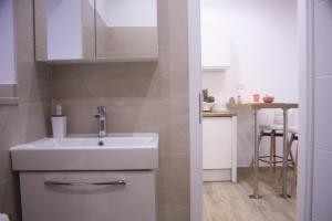 a bathroom with a sink and a kitchen with a table at M-Dream, in heart of Split in Split