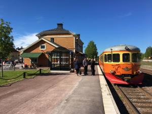 an orange train is stopped at a train station at Orsa Station Bed and Breakfast in Orsa