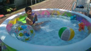 a young boy playing in a pool with a ball at Hua Qing Yuan in Yuanshan