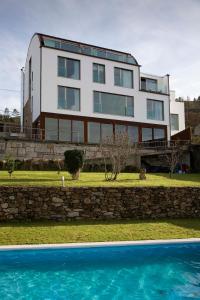 a house with a swimming pool in front of it at Hotel de Naturaleza AV - Adults Only in Ameixenda