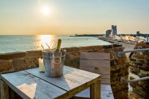 un cubo de vino sentado en una mesa junto a la playa en De Gevangentoren Suite, en Vlissingen