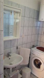 a bathroom with a sink and a washing machine at Apartment Krizanovic in Malinska