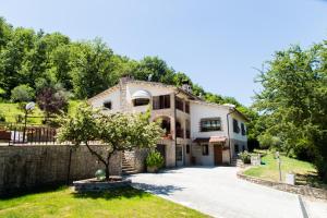 eine Villa mit einem Garten und einer Auffahrt in der Unterkunft Piccoli Sogni in Valfabbrica