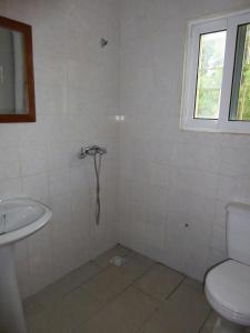 un baño con inodoro y lavabo en Sarawally Guesthouse, en Ampaya