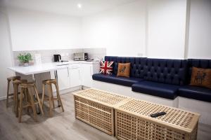 een woonkamer met een blauwe bank en een keuken bij Fleet Street - Perfect for Nightlife! in Liverpool