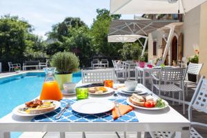 una mesa con platos de comida junto a una piscina en Villa Borgo Duino, en Duino