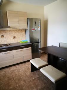 a kitchen with a stainless steel refrigerator and a table at Liela Guest Apartament in Liepāja +21 photos