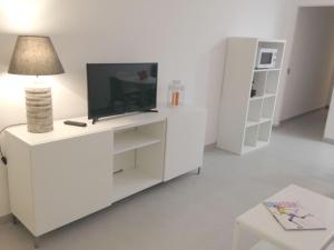 un centro di intrattenimento bianco con televisore e lampada di Casa Montechoro ad Albufeira