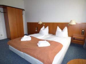 Una habitación de hotel con una cama con toallas. en Pension Seeterrasse, en Serwest