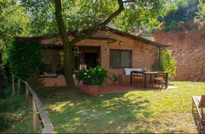 a brick house with a table and chairs in a yard at Marziani Rustic Tuscan House in Capannori