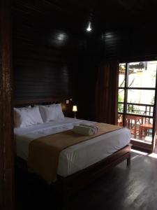 een slaapkamer met een bed met een lamp en een raam bij Linda Beach Hotel in Nusa Lembongan
