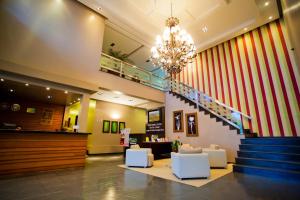 a lobby with a chandelier and a staircase with white chairs at Aipana Plaza Hotel in Boa Vista