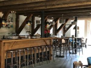 een bar met krukken in een kamer met houten balken bij Hotel Lemmer in Lemmer