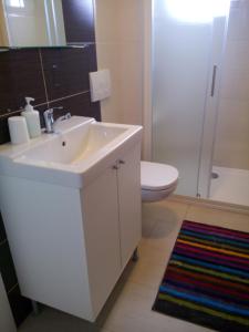 a white bathroom with a sink and a toilet at Rooms Marina in Korenica +32 photos