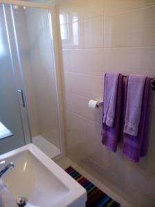 a bathroom with a sink and a shower with purple towels at Rooms Marina in Korenica