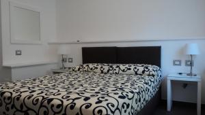 un lit noir et blanc dans une chambre blanche dans l'établissement Il Melograno B&B, à Castellaneta Marina