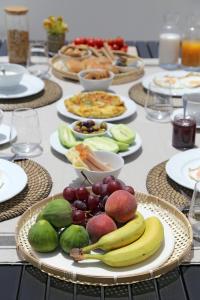 a table topped with plates of fruit and food at Vino Houses in Oia