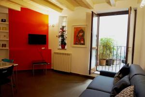 a living room with a couch and a red wall at Studio Apartment Vicolo Lavandai in Milan