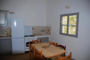 a kitchen with a table and a white refrigerator at Residence Ribellinu in Pianottoli-Caldarello