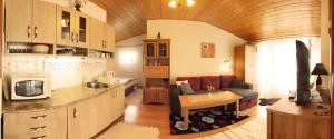 eine Küche und ein Wohnzimmer mit einem Sofa und einem Tisch in der Unterkunft Apartmány Zuberec - Julius a Agnes in Zuberec