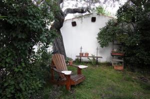 a chair sitting next to a tree in a yard at Le Case Della Posta in Santo Stefano di Sessanio