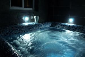 a jacuzzi tub in a bathroom at night at Chata Orlik - all inclusive & wellness in Pec pod Sněžkou