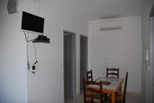 a dining room with a table and a television on a wall at Residence Ribellinu in Pianottoli-Caldarello