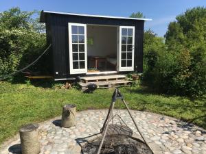 a black tiny house with a tripod in front of it at Villa Thurø Homestay in Svendborg