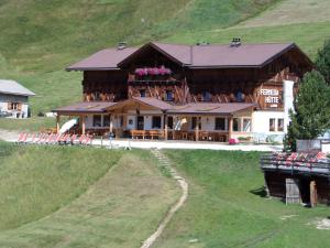 a large wooden house on top of a hill at Rifugio Fermeda Hutte in Santa Cristina in Val Gardena