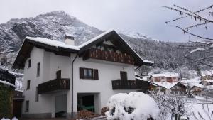 una casa bianca con la neve sul tetto di Casa La Guarda a Stenico