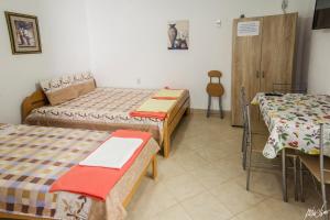 Pokój z 2 łóżkami, stołem i krzesłami w obiekcie Apartmani Pe-Ko w mieście Star Dojran