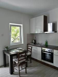 a kitchen with a table and a table and chairs at Apartments Lucija in Senj