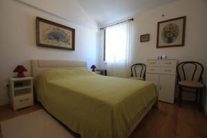 ein Schlafzimmer mit einem Bett, einer Kommode und einem Fenster in der Unterkunft Apartment Lidija in Bobovišća
