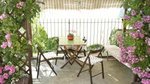 eine Terrasse mit Tisch, Stühlen und Blumen in der Unterkunft Cit Ni in Bosia + 18 Fotos