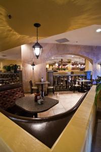 un restaurante con mesas y sillas y un bar en Tuscany Suites & Casino en Las Vegas